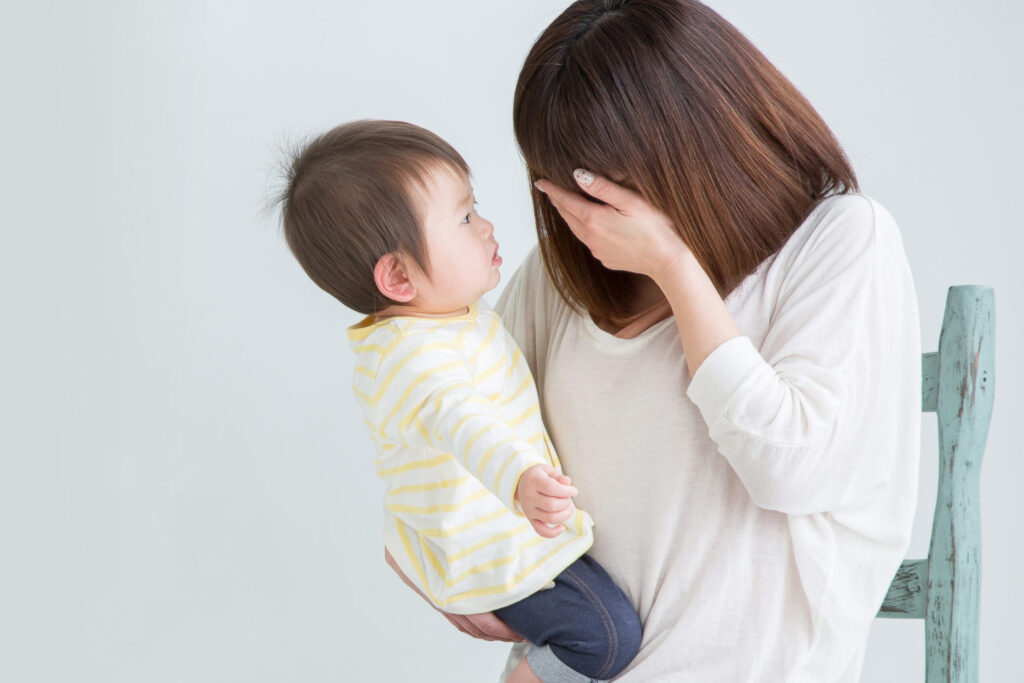 赤ちゃんを抱いて孤独を感じる女性